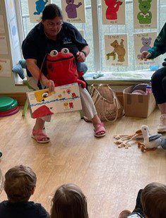 Member of education team reading Marmo Saves the Sea to a pre-school group in their pre-school setting.
