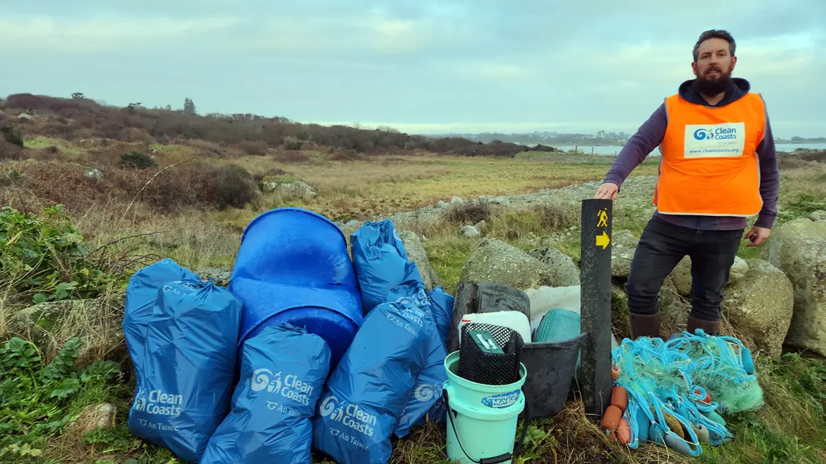 A Clean Coasts volunteer with a large mass of marine litter collected from a Beach.