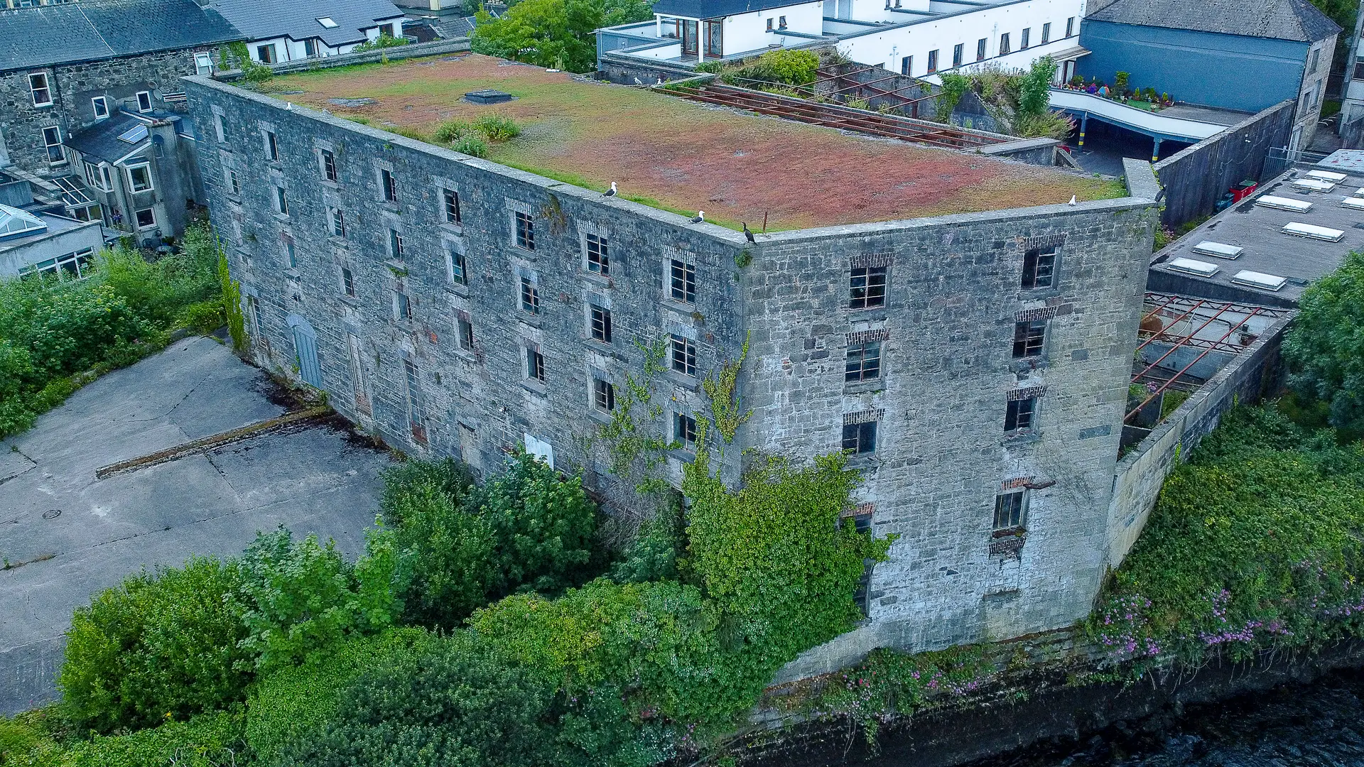 An old industrial building along the corrib river. A view of Persse's Galway Whiskey from a drone